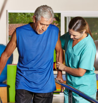 caregiver assisting her patient in walking