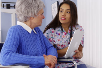 caregiver talking to her patient in wheelchair